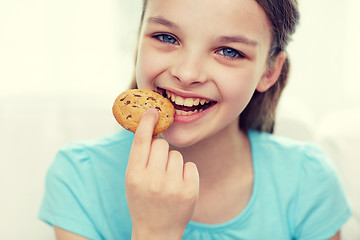 Image showing smiling little girl eating cookie or biscuit