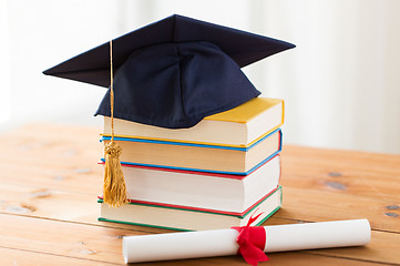 Image showing close up of books with diploma and mortarboard