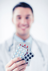 Image showing male doctor with packs of pills