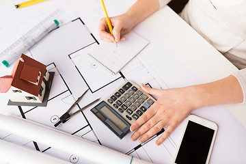 Image showing close up of architect hand counting on calculator