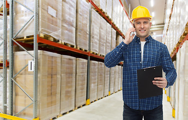 Image showing man with clipboard and smartphone at warehouse