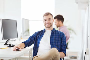 Image showing happy creative man with cellphone at office