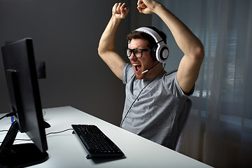 Image showing man in headset playing computer video game at home