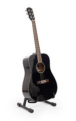 Image showing Black acoustic guitar on stand, isolated