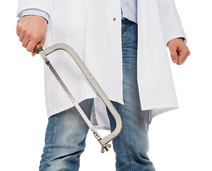 Image showing Crazy doctor is holding a big saw in his hands