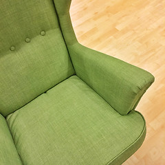 Image showing Stylish green armchair on wooden floor