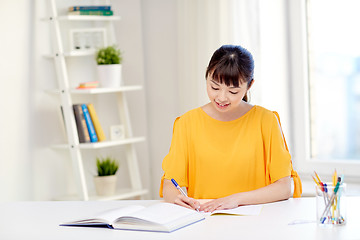 Image showing happy asian young woman student learning at home