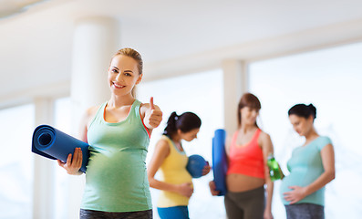 Image showing pregnant woman with mat in gym showing thumbs up 