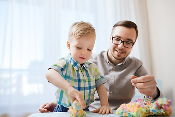 Image showing father and son playing with ball clay at home