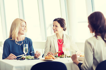 Image showing happy women eating and talking at restaurant