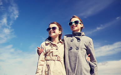 Image showing happy little girls in sunglasses hugging outdoors