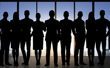 Image showing business people silhouettes over office background