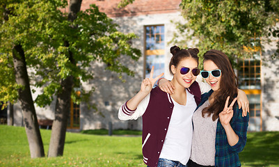 Image showing smiling teenage girls in sunglasses showing peace