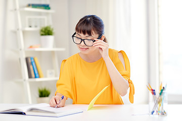 Image showing happy asian young woman student learning at home