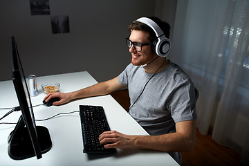 Image showing man in headset playing computer video game at home