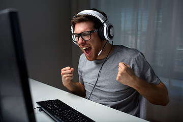 Image showing man in headset playing computer video game at home