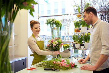 Image showing smiling florist woman and man at flower shop