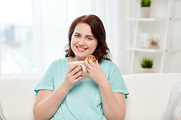 Image showing happy plus size woman with cup and cookie at home