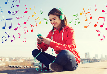 Image showing happy young woman with smartphone and headphones