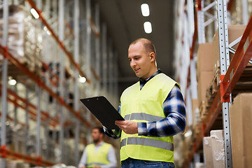 Image showing man with clipboard in safety vest at warehouse