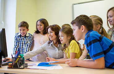 Image showing group of kids with teacher and computer at school