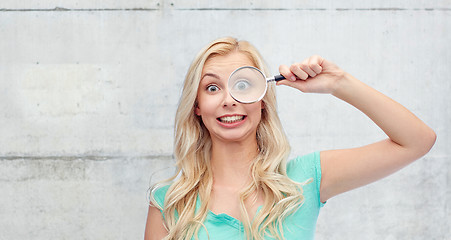 Image showing happy young woman with magnifying glass