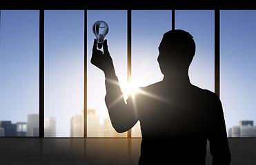 Image showing silhouette of businessman holding light bulb