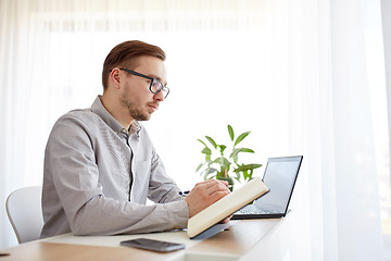 Image showing creative man or businessman writing to notebook