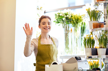 Image showing smiling florist woman at flower shop cashbox