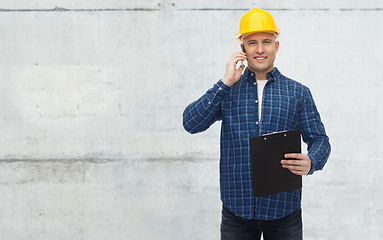 Image showing smiling builder in helmet calling on smartphone