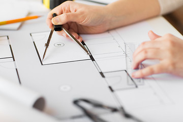 Image showing close up of hands with compass measuring blueprint