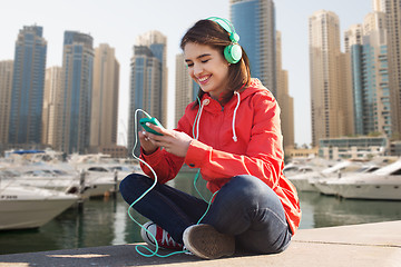 Image showing happy young woman with smartphone and headphones