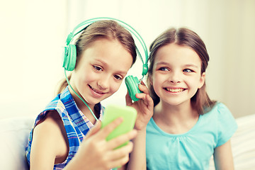 Image showing happy girls with smartphone and headphones