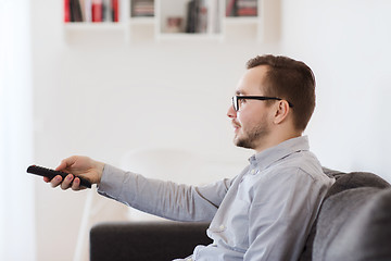 Image showing smiling man with tv remote control at home