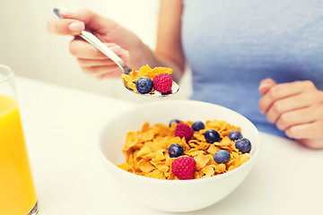 Image showing close up of woman eating corn flakes for breakfast