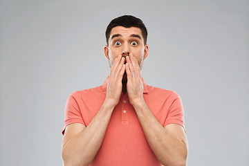 Image showing scared man in polo t-shirt over gray background