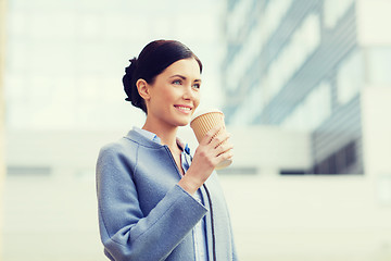 Image showing smiling woman drinking coffee in city