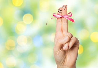 Image showing close up of two fingers tied by pink bow knot