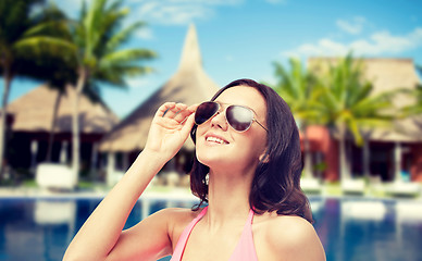 Image showing happy woman in sunglasses and swimsuit on beach