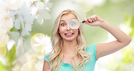 Image showing happy young woman with magnifying glass