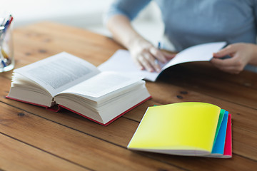 Image showing close up of student with book and notebook at home