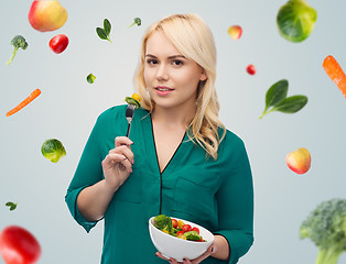 Image showing smiling young woman eating vegetable salad