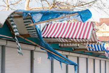 Image showing Torn fabric awnings over the closed seaside shops in the offseason