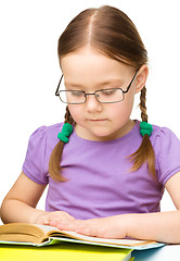 Image showing Little girl is reading a book