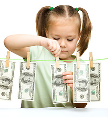 Image showing Cute little girl is playing with paper money