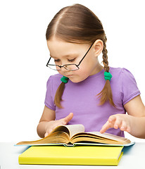 Image showing Little girl is reading a book