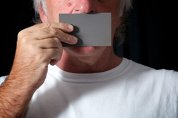 Image showing man holding card over mouth