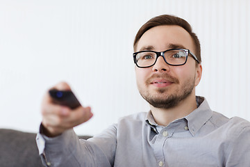 Image showing smiling man with tv remote control at home