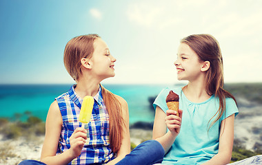 Image showing happy little girls eating ice-cream over beach