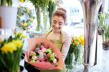 Image showing smiling florist woman with bunch at flower shop